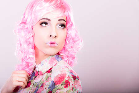 Portrait woman with pink wig creative visage makeup on gray background