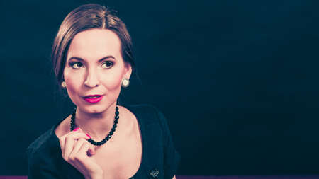 Fashion beauty and elegance concept. Woman retro style portrait. Elegant lady hair styling red lips on blackの写真素材