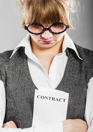 Business documents legal concept - closeup skeptical unhappy businesswoman holding contract in hands. Negative human emotion face expression feeling reactionの写真素材