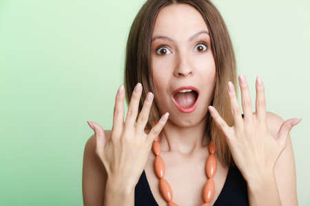 Emotional facial expression wide eyed woman surprised girl open mouth hand gesture.の写真素材