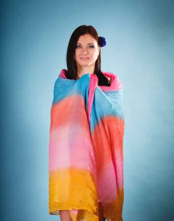 Summer fashion. Beauty young woman fashionable sensual girl with coloured shawl on blue backgroundの写真素材