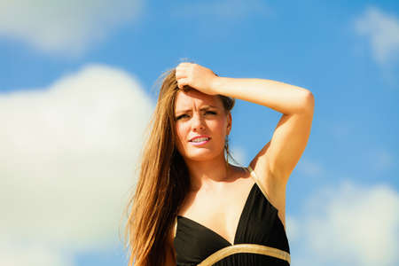 Little shocked woman on beach. Long hair girl model blue sky.の写真素材