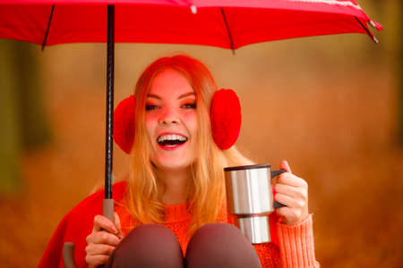 Happiness carefree and fall concept. Young woman in red relaxing in autumn park on bench under...