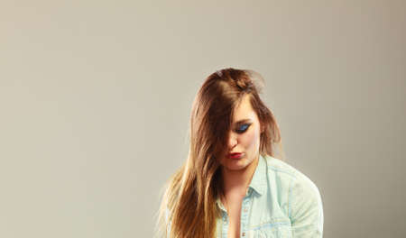 Woman with unhappy offened face expression copy space on gray backgroundの写真素材