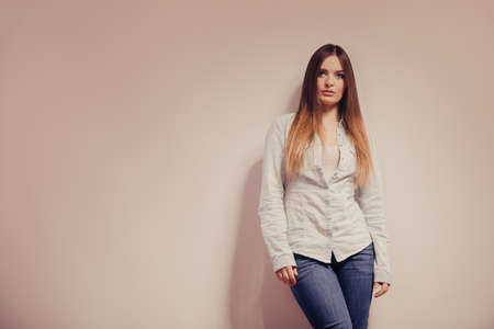 Fashion. Young long hair fashionable woman jeans pants shirt. Female model posing text area filtered photoの写真素材