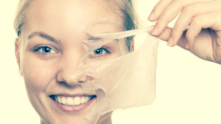 Beauty skin care cosmetics and health concept. Closeup young woman face, girl removing facial peel off mask. Peeling.   の写真素材