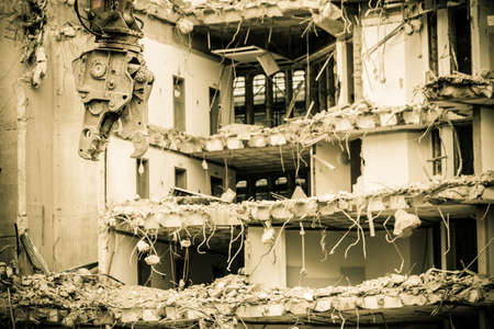 Urban scene. Dismantling of a house. Building demolition and crashing by machinery for new construction. Industry.の写真素材