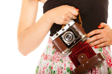 Retro Shooting. Closeup part of body, woman holding old vintage camera in hands isolated on white backgroundの写真素材