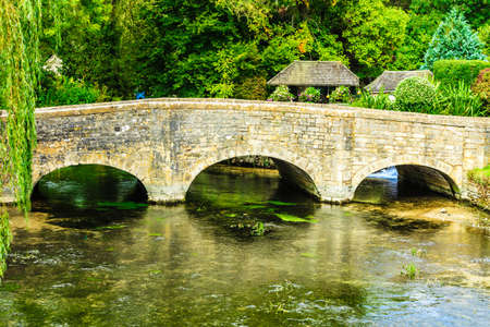 Old stone bridge over river Coln in Village Bibury, England UK. Nature landscape.の写真素材