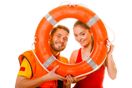 Happy lifeguards with ring buoy in life vest jacket. Man and woman having fun. Accident prevention.の写真素材