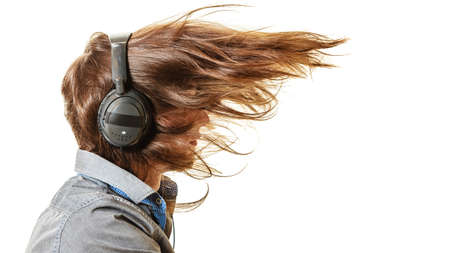 Passionate music lover with long hair flying. Young man listening through headphones relaxing...