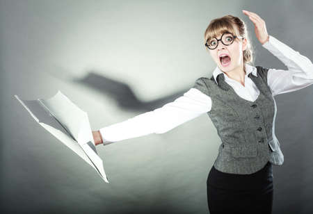 Fly fear metaphor, aerophobia concept. Business woman holding airplane in hand.の写真素材