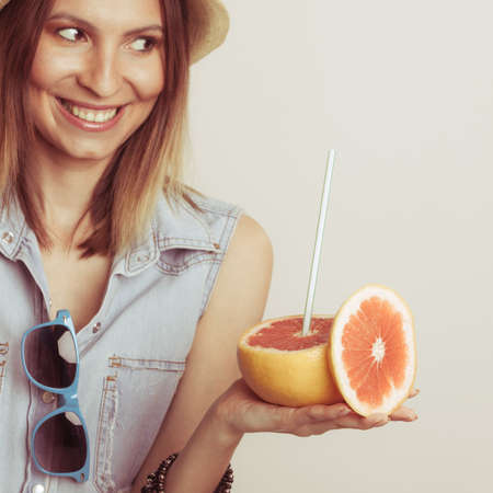 Happy glad woman tourist in straw hat with sunglasses and grapefruit citrus fruit. Healthy diet food. Summer vacation holidays concept.の写真素材