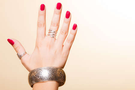 Closeup female hand, woman showing fashionable accessories bijouterie armlet and rings on finger....