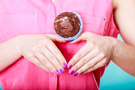 Hands making heart shape holding delicious tasty sweet chocolate muffin. Confectionery food love.の写真素材