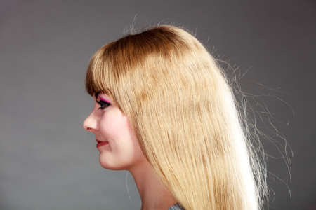 woman face profile with makeup and long blond hair on gray 