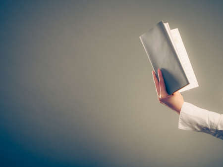 Closeup of human reading and learning with book textbook  studying for exam. Education leisure.  の写真素材