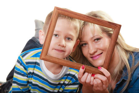 Happy family and love concept. Portrait of middle-aged mother with son little boy holding frame decorations studio shot isolated on whiteの写真素材