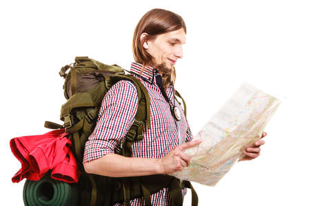 Man tourist backpacker reading map on trip. Young guy hiker searching looking for direction guide. Male backpacking. Summer vacation travel. Isolated on white background.の写真素材