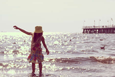 Little girl child kid walking on beach at sea. Summer vacation holidays relax and fun.の写真素材
