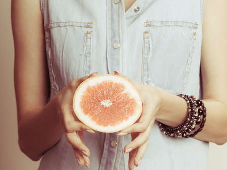 Human holding grapefruit citrus fruit. Healthy diet food.の写真素材