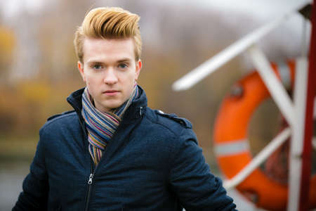 Young handsome man fashion model casual style hair styling outdoor against a marine harbourの写真素材