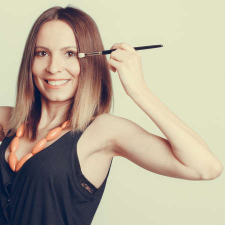 Woman stylist applying eye shadow professional makeup brush. Girl beautifying eye eyelid. Make up...