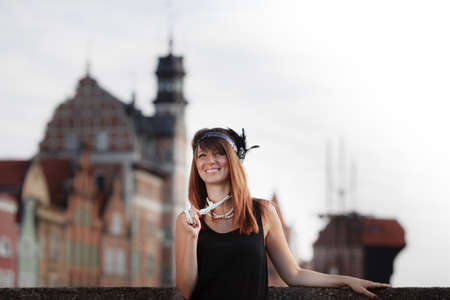 Flapper girl. Retro style fashion vintage woman from roaring 1920s outdoor on the street. Old town Gdansk Danzig in the backgroundの写真素材