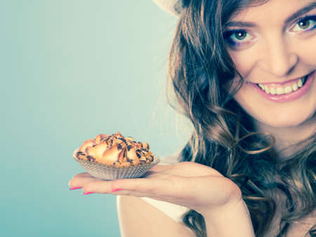 Sweet food sugar make us happy. Attractive woman holds cake in hand filtered photo