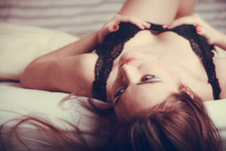 Seductive sexy gorgeous woman wearing lingerie in bed at home. Attractive sensual young girl with...