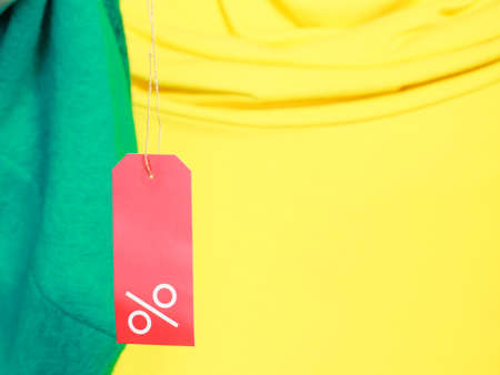 Shopping and sale concept. Closeup red label with percent sign and copy space on yellow green color...