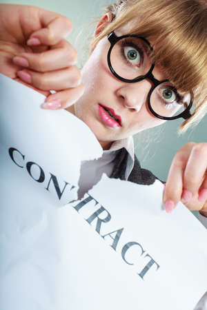 Business, documents and legal concept - serious unhappy businesswoman tearing crumpled contractの写真素材