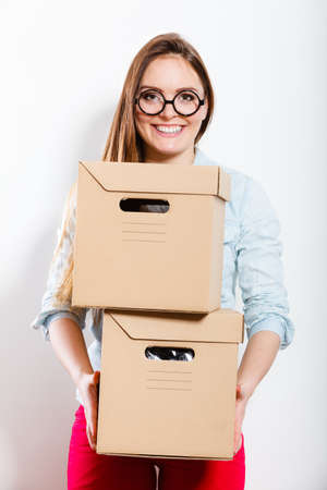 Happy woman moving in carrying cartons boxes. Young girl arranging interior and unpacking at new...