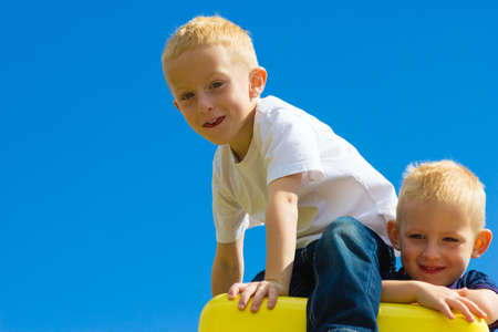 Children kids in playground climbing on leisure equipment. Boys playing outside. Active and happy childhood.の写真素材