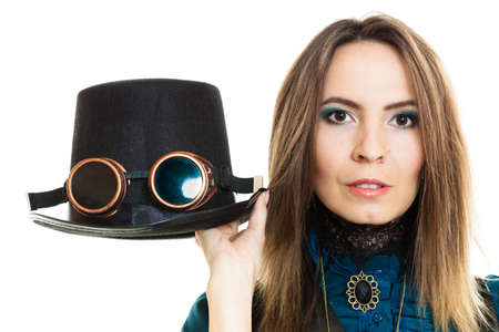 Young steampunk islolated girl on white holding fancy hat. Fantasy old fashion with stylish topper and goggle.の写真素材