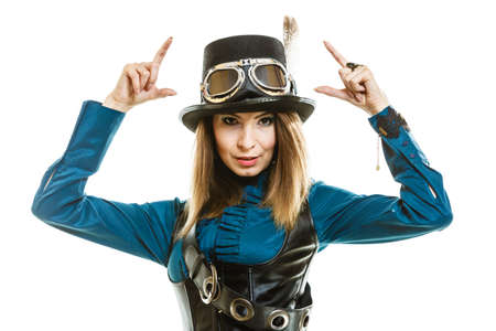 Young steampunk islolated girl on white wearing fancy hat. Fantasy old fashion with stylish topper and goggle pointing.の写真素材