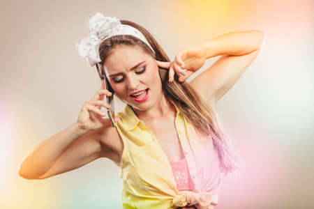 Retro pin up attractive girl talking on mobile phone. Woman with cellphone using technology.の写真素材