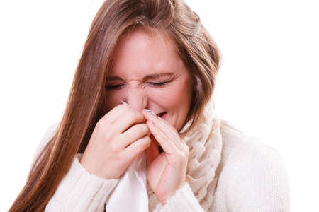 Flu cold or other virus. Sick woman girl with fever sneezing in tissue, suffering from quinsy....