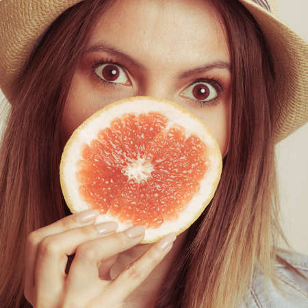 Woman having fun covering her mouth with grapefruit. Happy summer vacation holiday. Healthy food. 
の写真素材