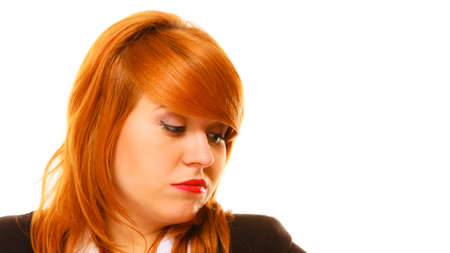 Women in business. Job concept. Disappointed young red haired businesswoman on white background in studio.の写真素材