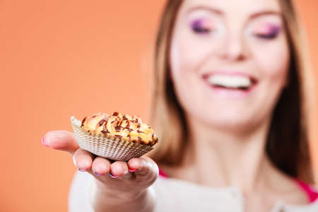 Happy woman holding delicious cupcake cake. Appetite and gluttony concept.の写真素材