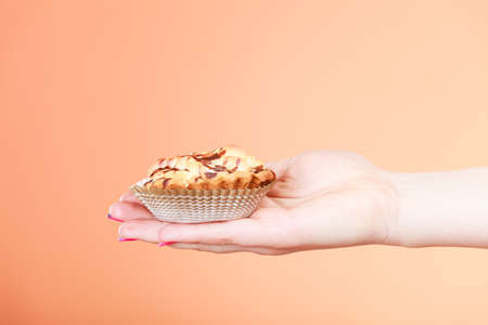 Delicious tasty sweet cake cupcake in human hand.の写真素材