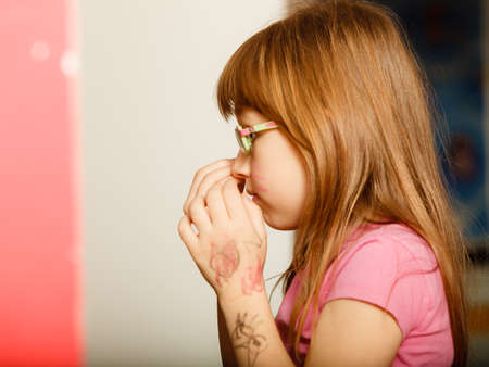 Childhood and development concept. Little girl schoolchild in glasses with the body painted, face profileの写真素材