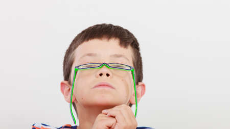 Portrait close up of cute serious kid little boy in glasses.の写真素材