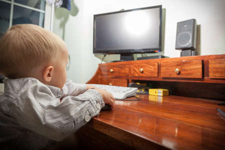 Happy childhood. Smart little boy child kid playing on the desktop computer at home. Technology.
