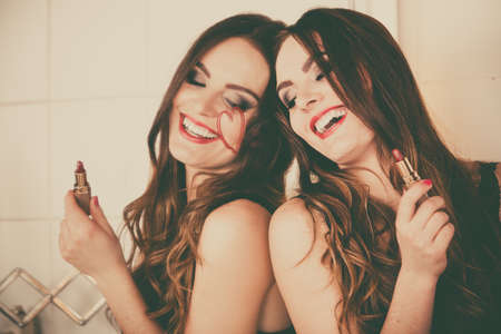 Pretty girl having fun in bathroom. Funny concept during makeup. Draw of heart. Retro styleの写真素材