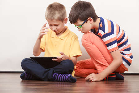 Children playing on tablet. Having fun and learningの写真素材