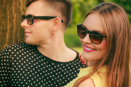 Love and happiness. Young happy couple lovers wearing sunglasses dating in summer park outdoor.