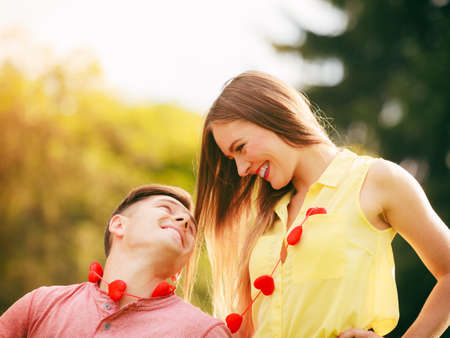 Love and dating. Young fashionable couple lovers with red hearts necklace outdoor.