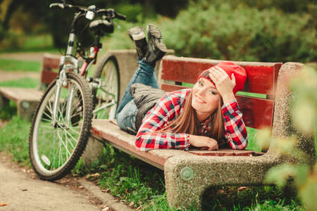 Fall active lifestyle concept,. Beauty young woman sporty casual girl relaxing in autumnal park with bicycle, outdoorの写真素材